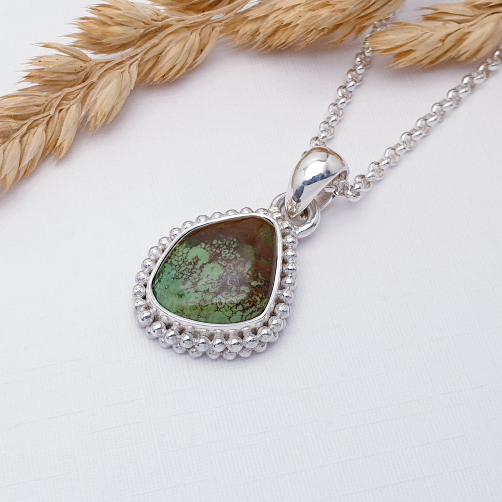 One-Off Turquoise Sterling Silver Boho Pendant on a white background with wheat in the top left corner. It is pictured on a Fine Belcher Chain