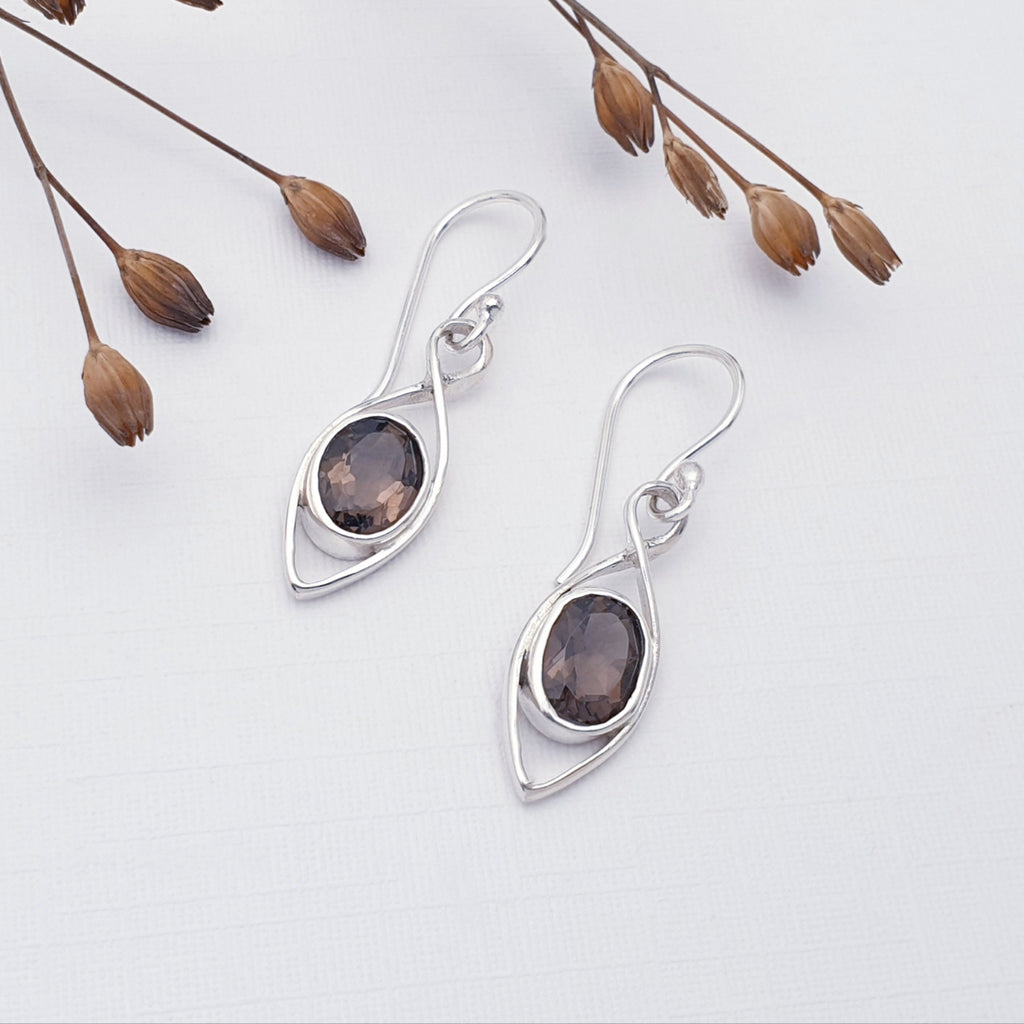 Smoky Quartz Raindrop Earrings on a white background with dried filigree in the top left corner