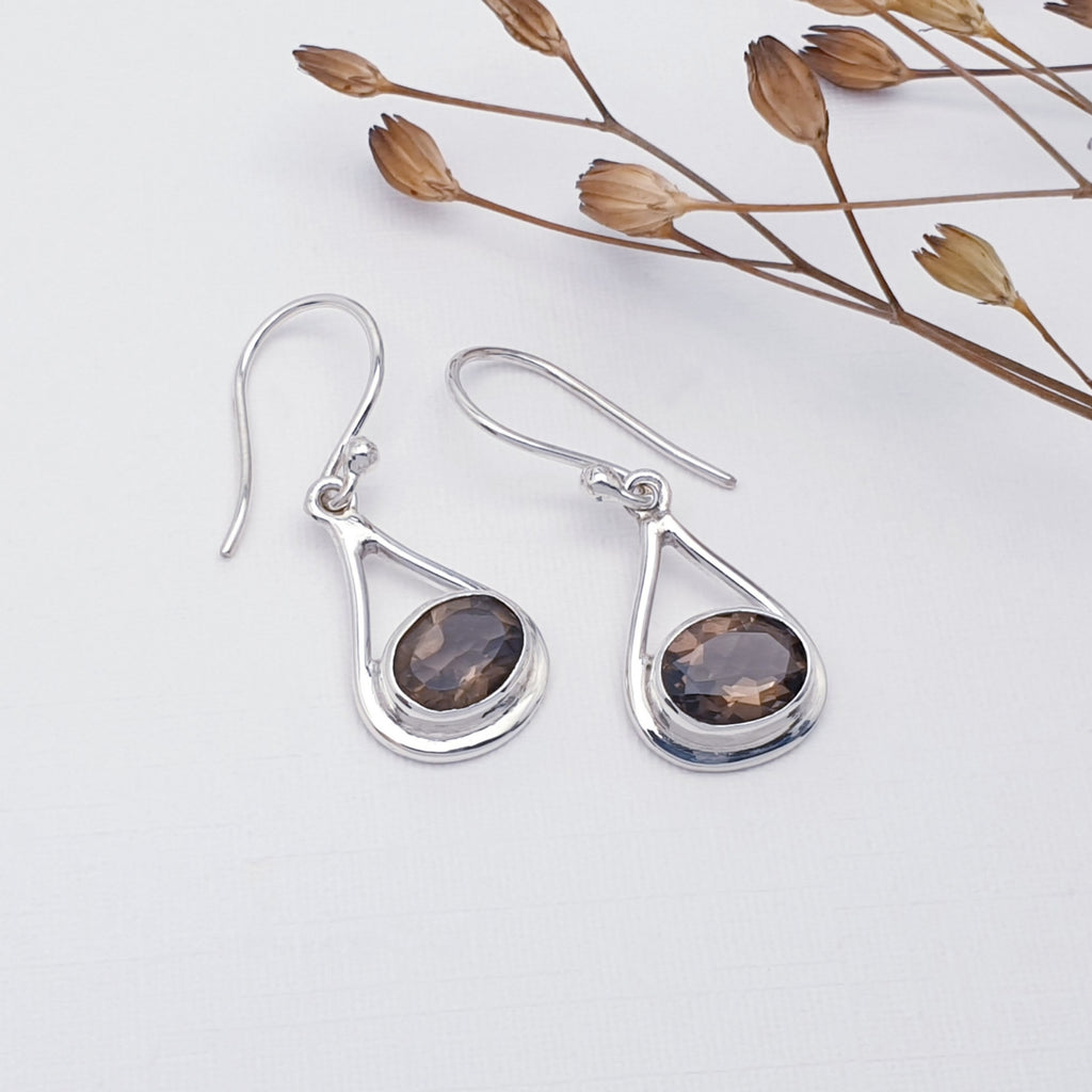 Smoky Quartz Valentina earrings on a white background with dried filigree in the top right corner.