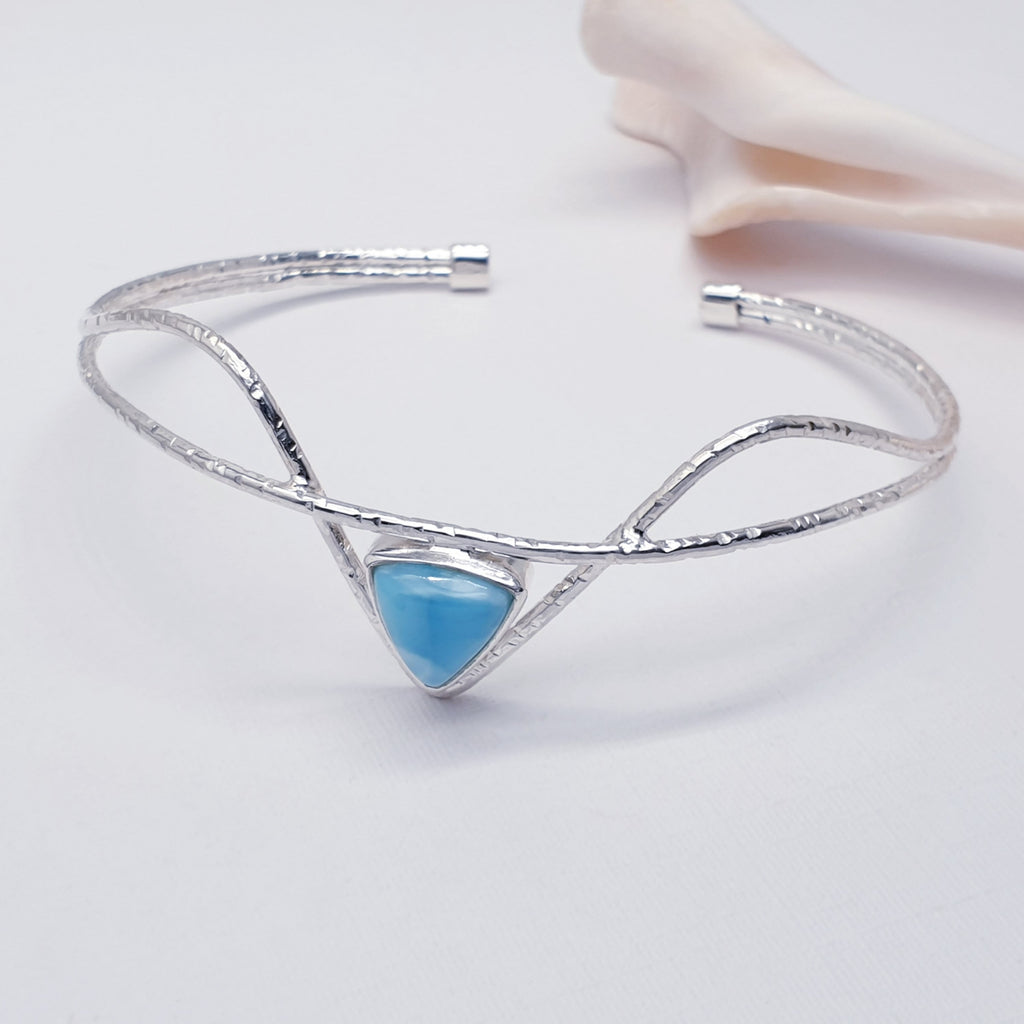 Our Sterling silver Larimar galatea cuff displayed on a white background with shells as decoration
