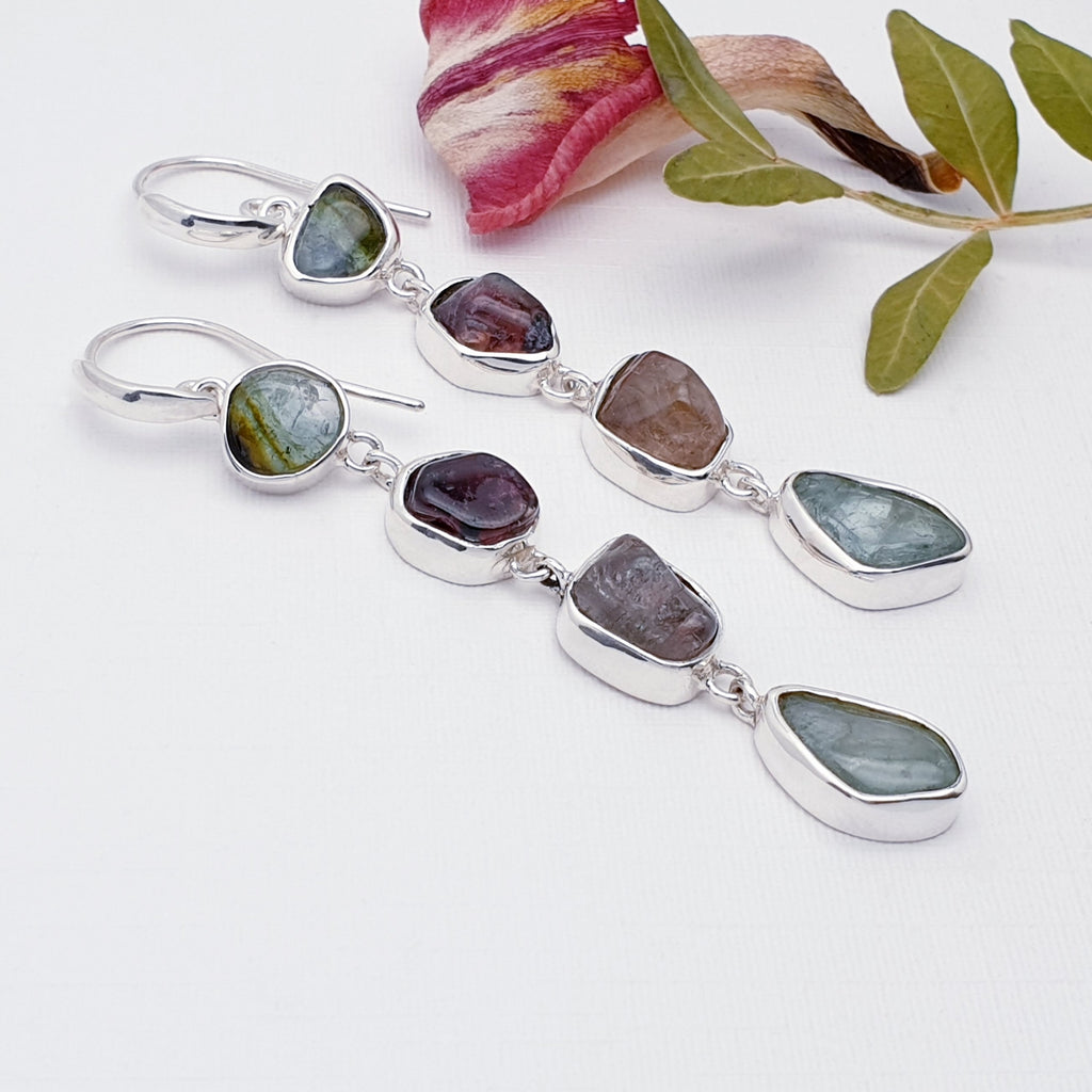 Silver earrings with multicolored Tourmaline stones on a white background