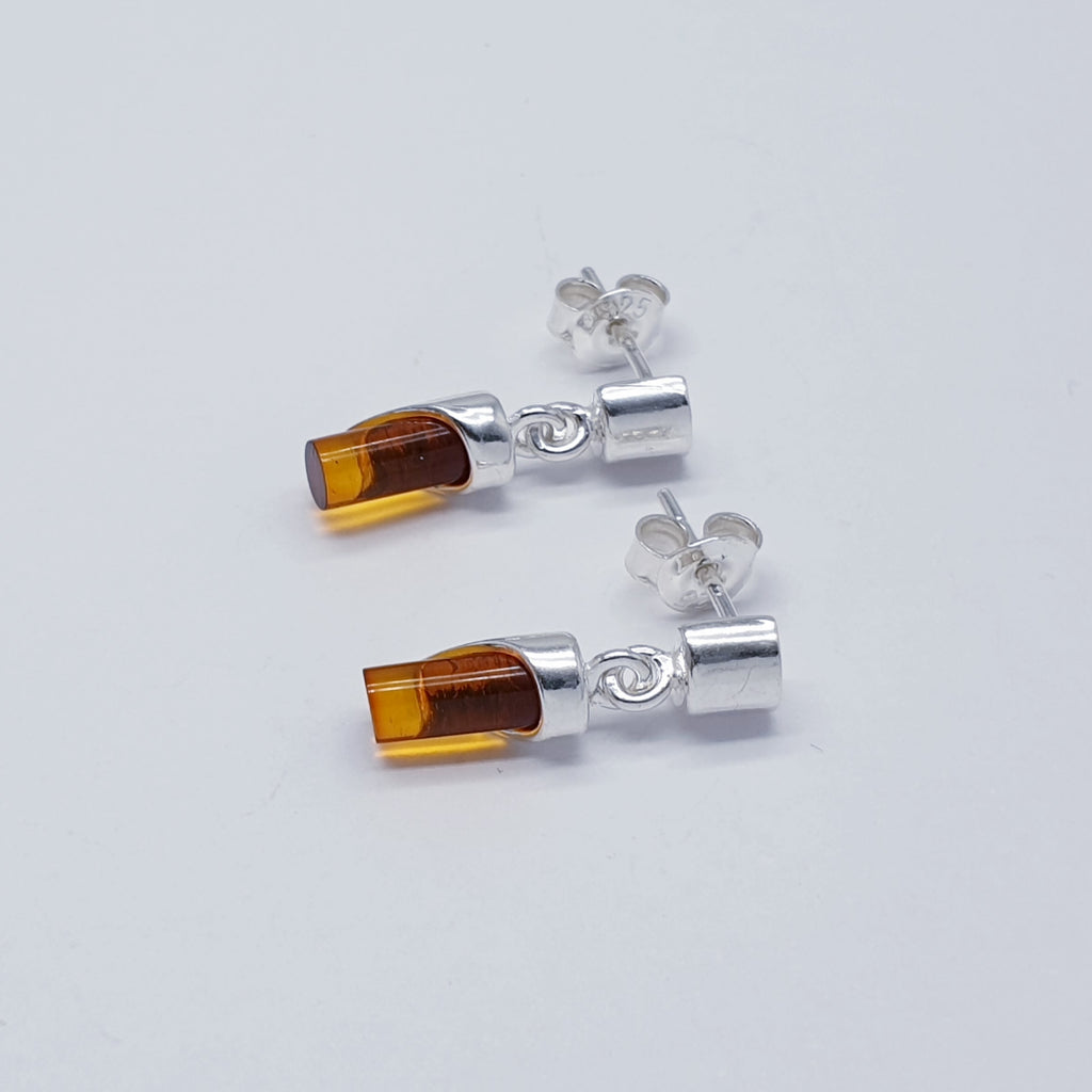 A pair of cylindrical amber and sterling silver earrings.