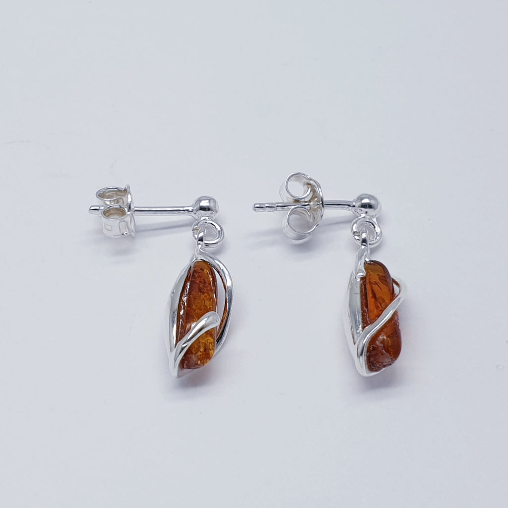 A pair of teardrop amber and sterling silver earrings.