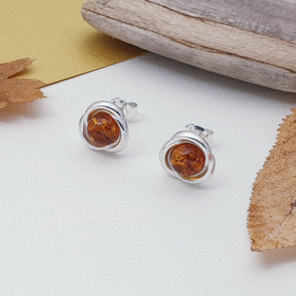 A pair of amber and sterling silver stud earrings.
