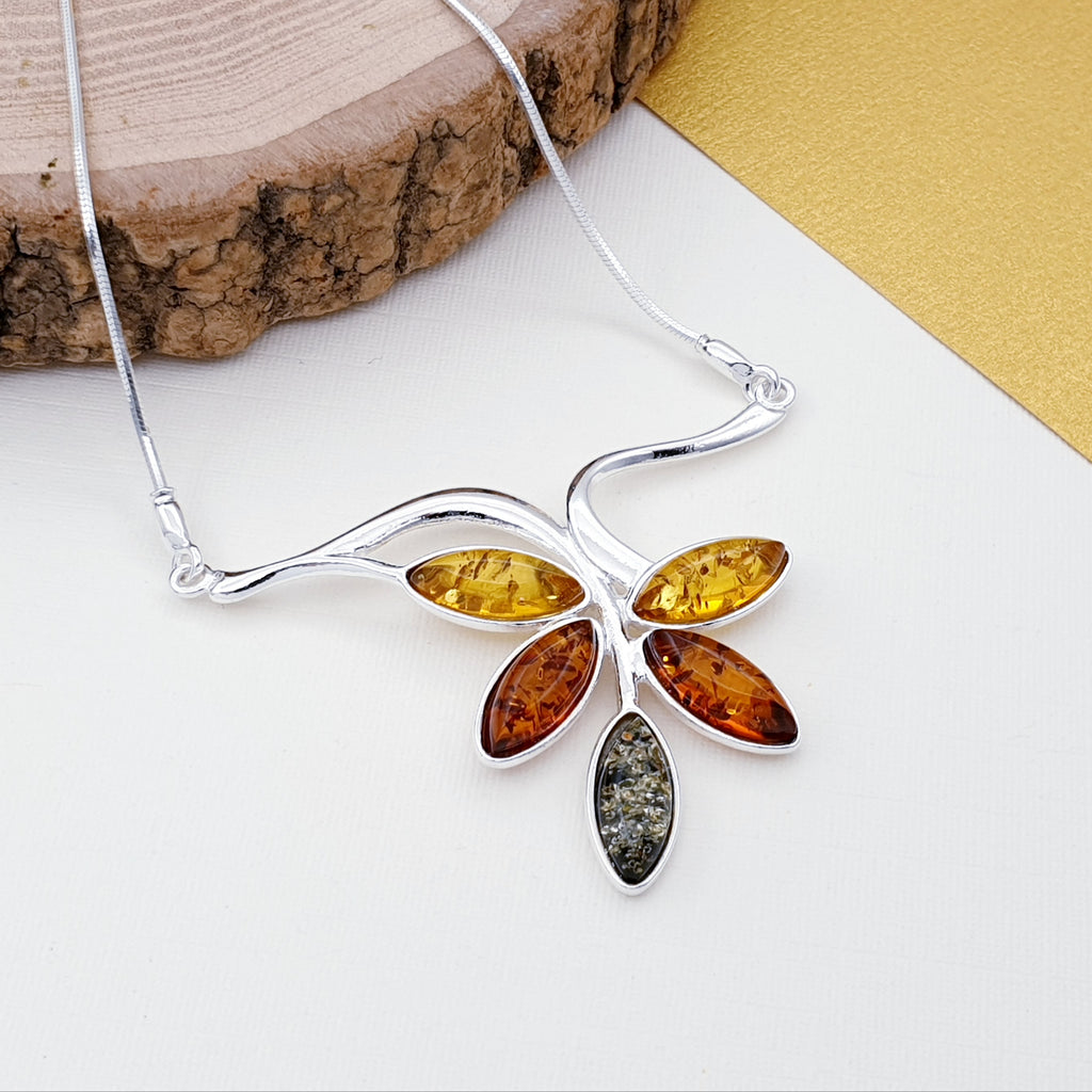 Our Mixed Amber Sterling Silver Vine Necklace is perfect for every day wear or special occasions.  A gorgeous design, this necklace features five marquise Baltic amber stones in toffee, yellow and green in simple settings. Each stone represents a little leaf on a Sterling silver hanging vine in this beautiful nature inspired design. 