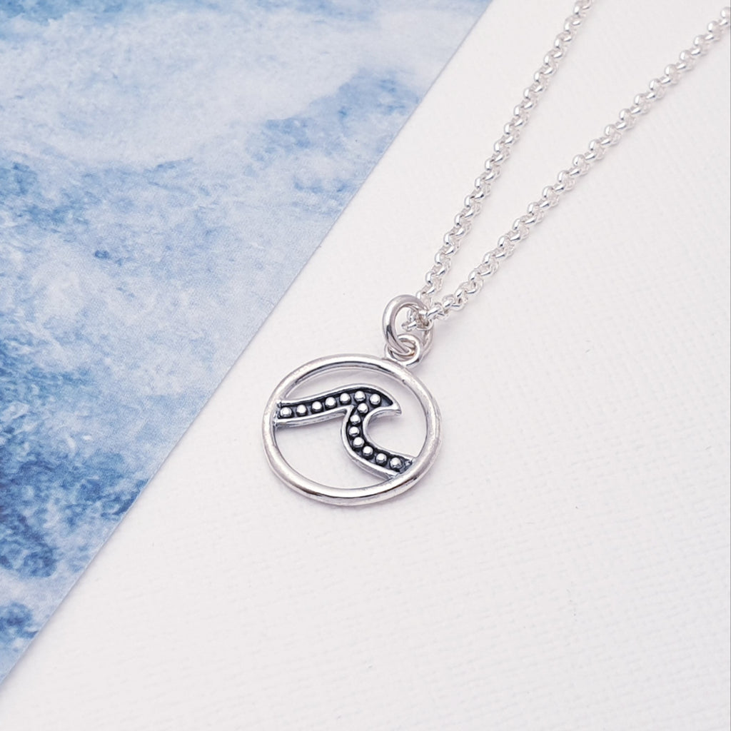 This beautiful pendant has taken inspiration from the sea. It features a detailed cut out design of a wave with an oxidised finish, giving it depth and presence, all in a circle shape.