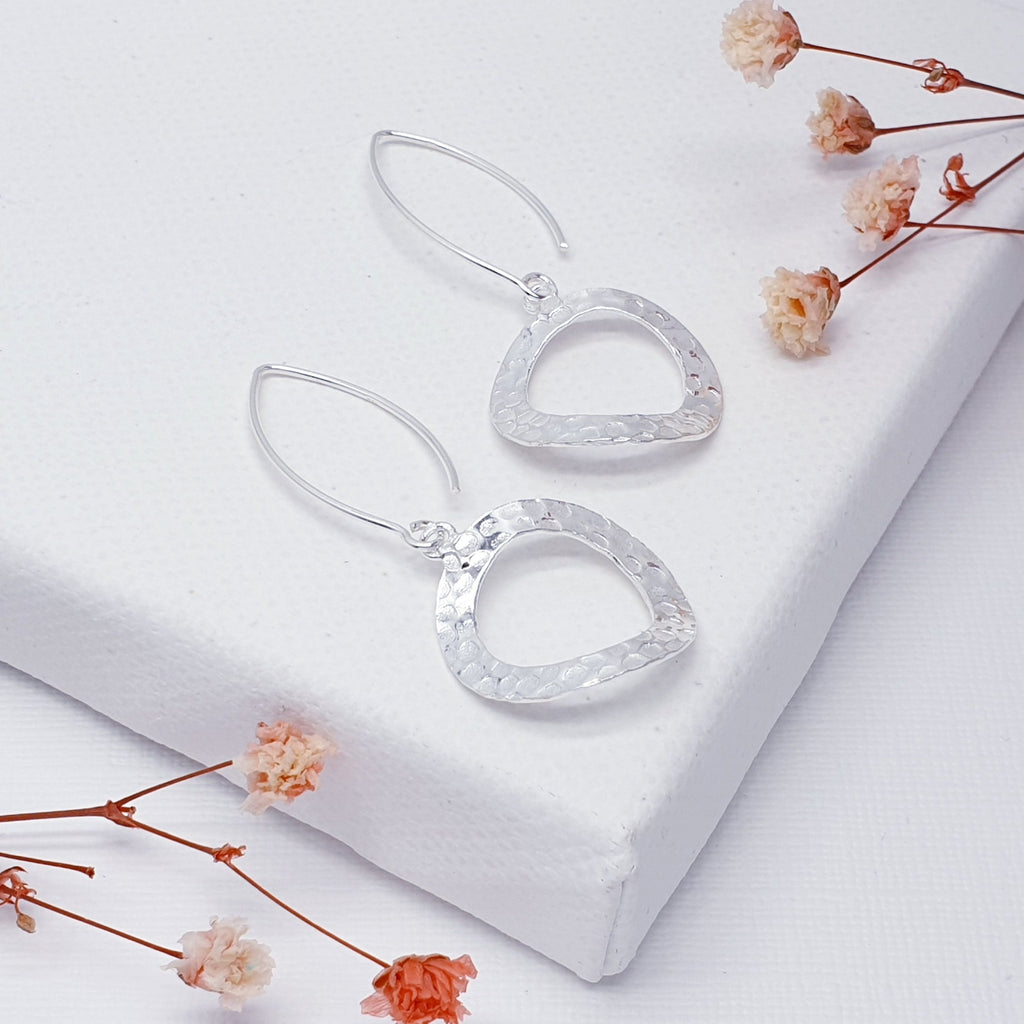 These gorgeous Silver earrings feature a hammered textured warped circle design. With the pull through feature, it gives these earrings a contemporary look and a touch of elegance, these dynamically different earrings are sure to catch the eye.