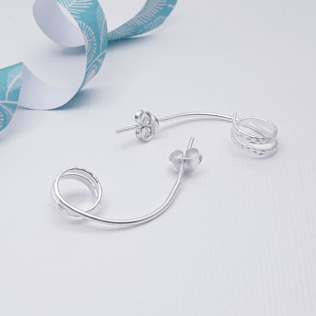A top-seller in our shops due to their simplicity, these little earrings are light on the ear, easy to wear and will complement any outfit. With a contemporary design, these stud earrings feature a subtle hammered effect on the spiral which will catch the light and make them sparkle. The stud fixing makes these earrings extra secure so you don't need to worry about them as you get on with your d