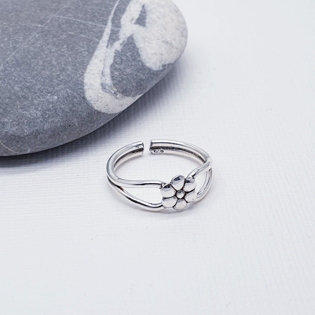 This toe ring features a Sterling Silver daisy design, that elegantly wrap around the toe. Open at the back, this toe ring is adjustable and should fit most toes.