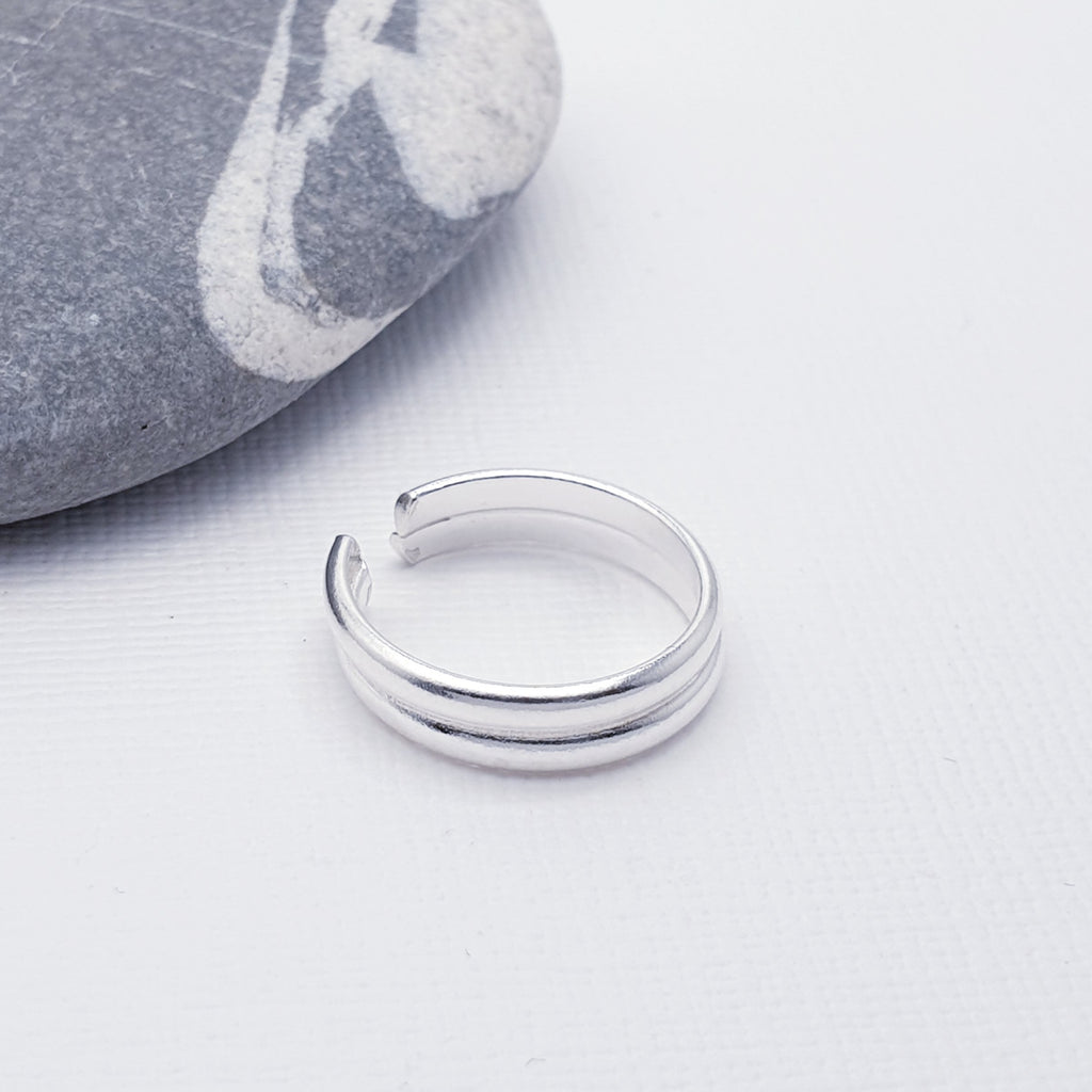 This simple design features two silver bands fused together creating an understated look which will complement any style or outfit. Open at the back, this toe ring is adjustable.