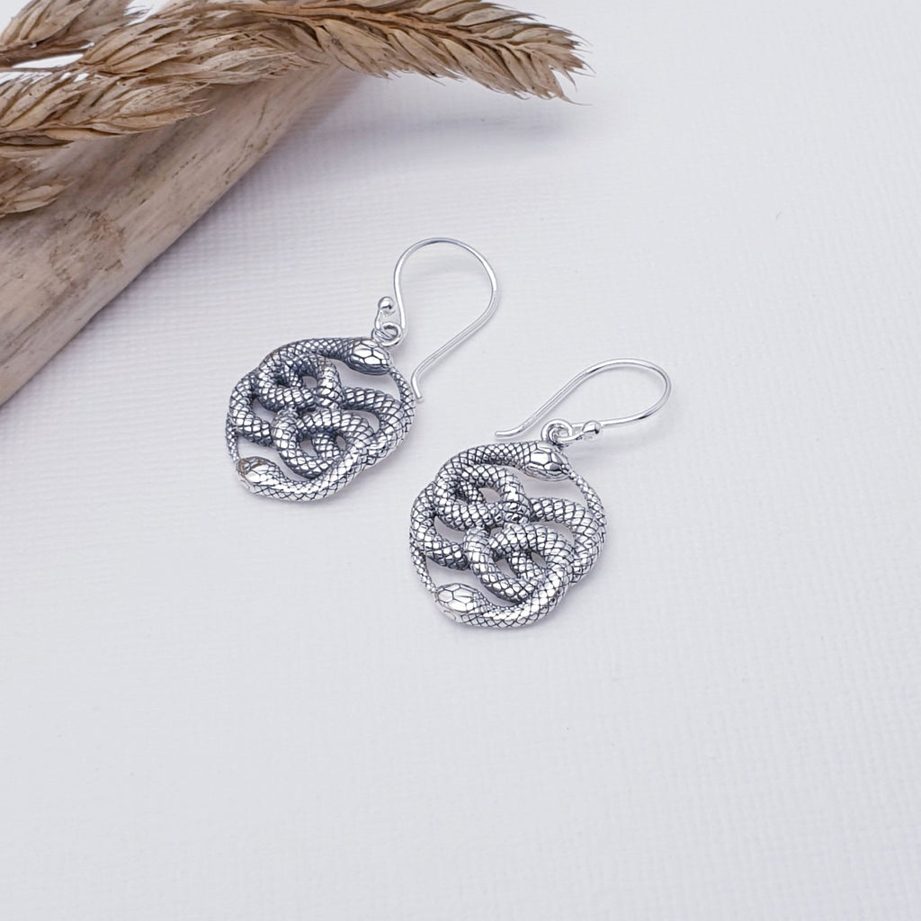Each earring features a Double Ouroboros symbol, two beautiful, detailed snakes with an oxidised finish, giving it depth and presence. A Double Ouroboros is a complicated symbol formed by a pair of twisted serpents consuming one another's tails. This ancient symbol represents the concept of eternity and endless return, as well as the unity of time's beginning and end.