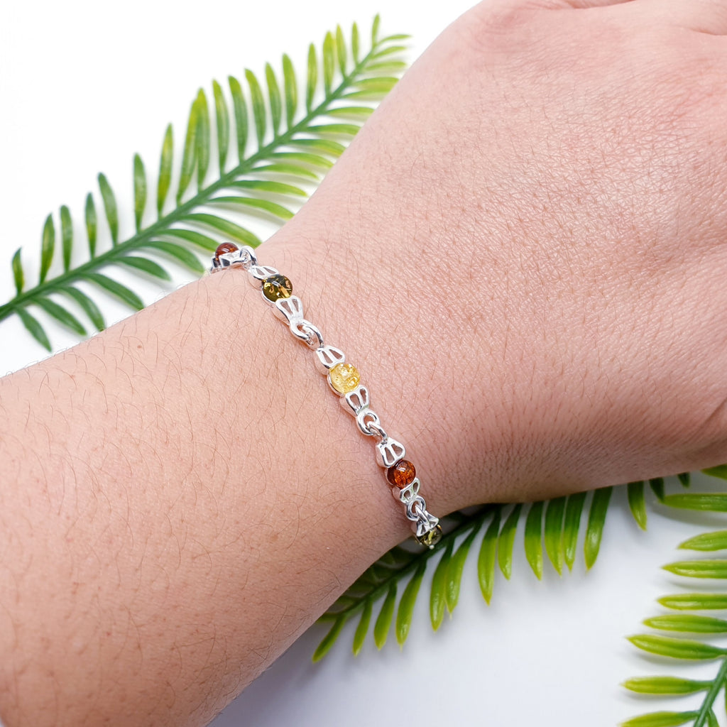 This beautiful bracelet features eleven, round, Baltic Amber stones; four Toffee Amber, three Green Amber and four Yellow Amber, all in Sterling Silver settings. Decorative silver links attach each stone to the next, creating a simple yet elegant and is bound to be well received.