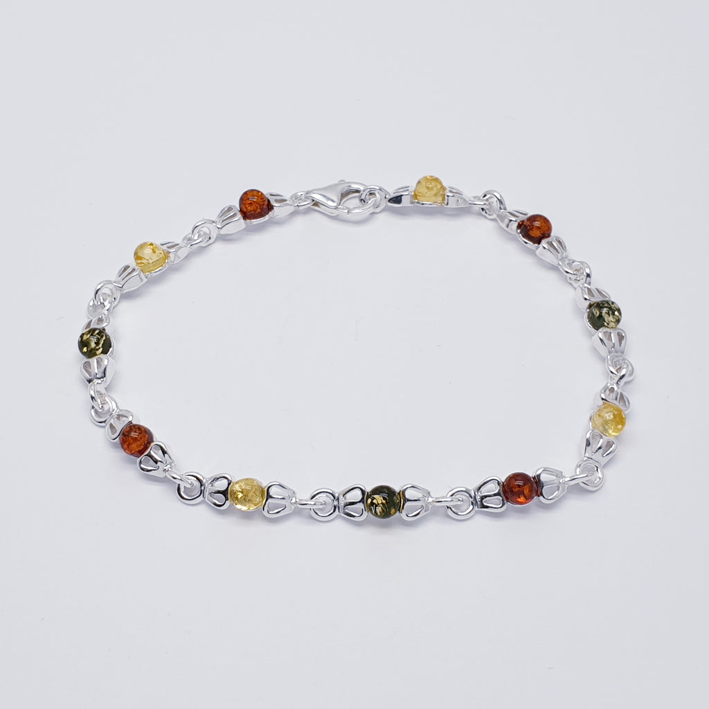 This beautiful bracelet features eleven, round, Baltic Amber stones; four Toffee Amber, three Green Amber and four Yellow Amber, all in Sterling Silver settings. Decorative silver links attach each stone to the next, creating a simple yet elegant and is bound to be well received.