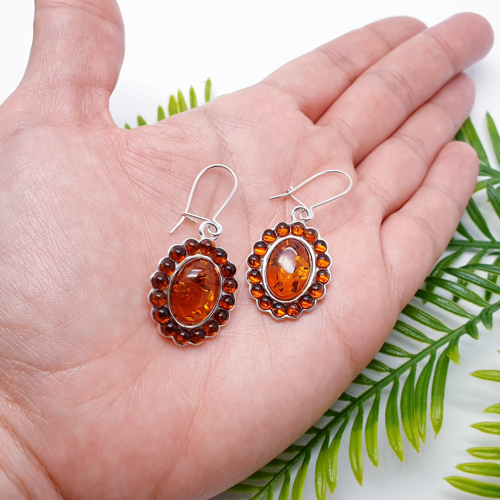 Each earring features an oval Baltic Toffee Amber stone with surrounding smaller circles, creating an exciting design. The perfect size, big enough so that the colour of the Amber can be appreciated but small enough so that they are not overpowering. These earrings will soon become everyday favourites. A closed hook fastening means that they are extra secure so you won't have to worry about loosing them.