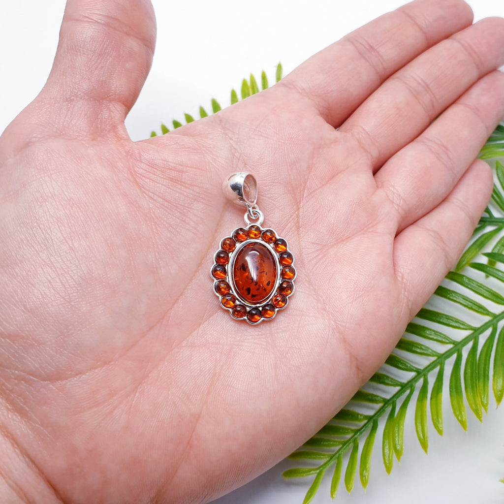 A simple design, this pendant features a beautiful oval Baltic Toffee Amber stone surrounded by smaller circle stones, creating an exciting design.  This pendant is perfect worn on a short chain as a statement piece, or on long chain layered with other necklaces creating your own unique look.
