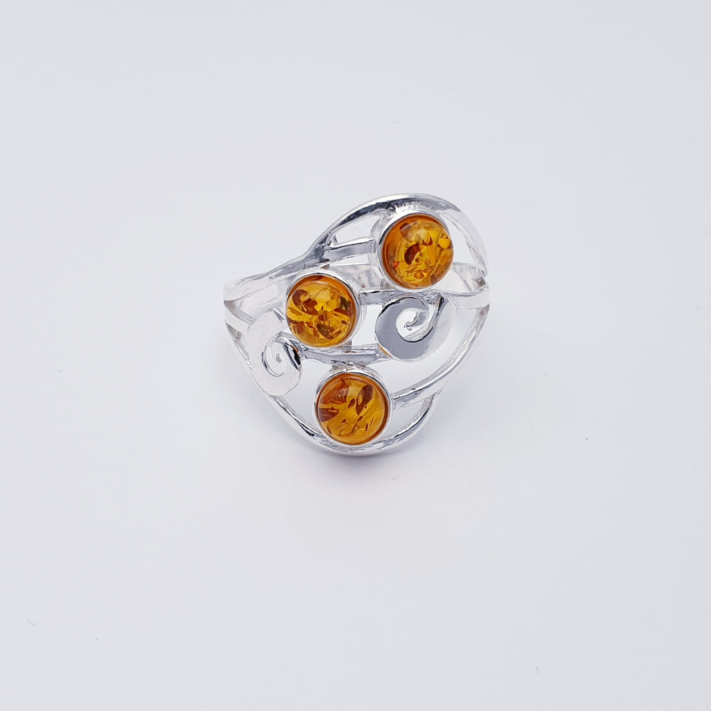 A classic design, this ring features three round Toffee Baltic Amber stones in simple settings. An elegant swirl shape design has been crafted in Silver, giving this ring that 'something a little different' we love so much at Silver Scene.