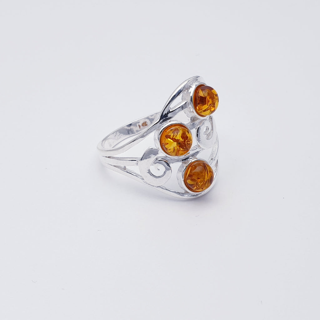 A classic design, this ring features three round Toffee Baltic Amber stones in simple settings. An elegant swirl shape design has been crafted in Silver, giving this ring that 'something a little different' we love so much at Silver Scene.