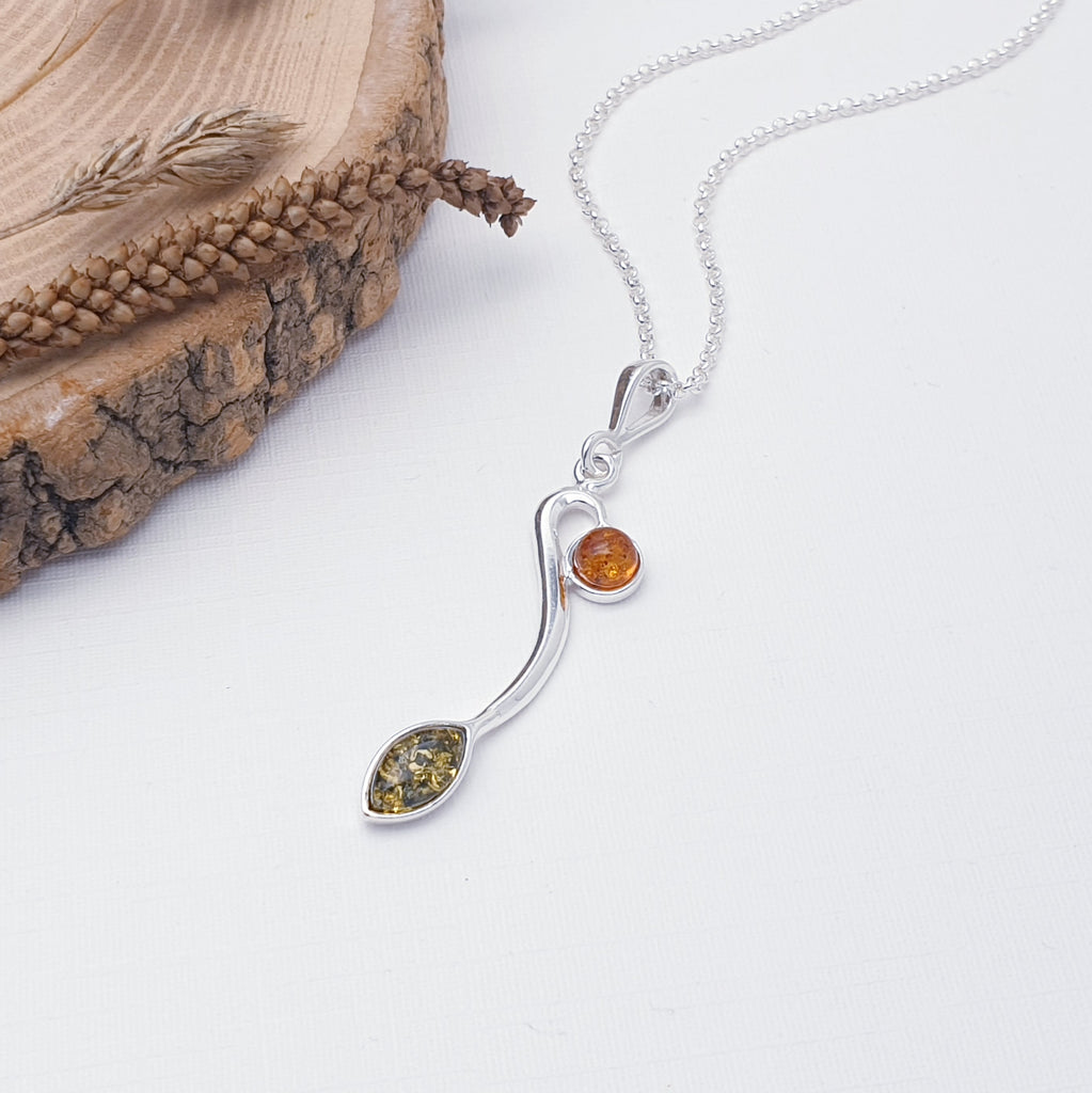 A beautiful design, this pendant features a marquise shape Green Amber stone and a small round Toffee Baltic Amber stone, both in Sterling Silver settings. A silver 'vine' compliments the stones in this gorgeous nature inspired design. 
