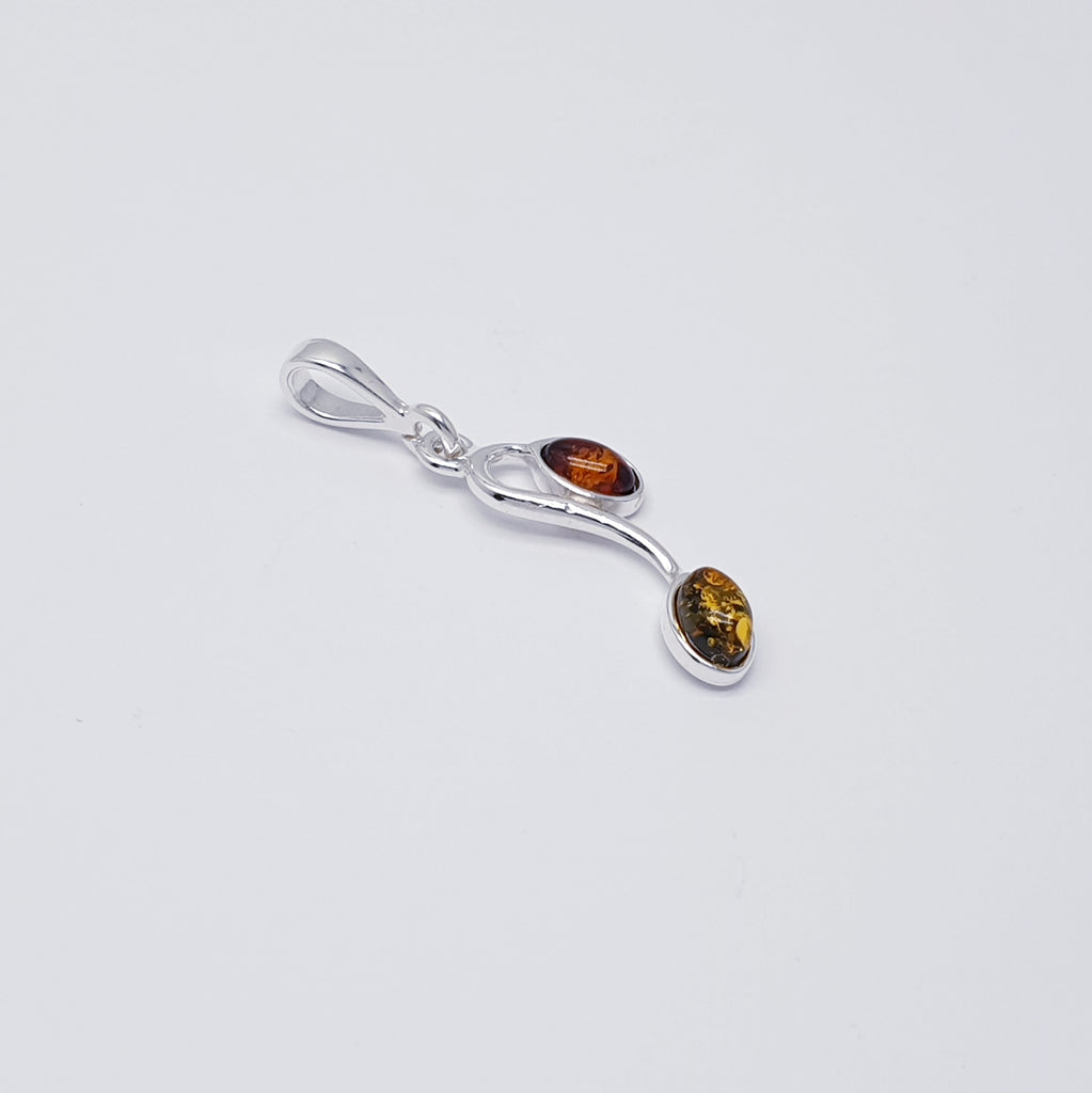 This gorgeous pendant features two oval Amber stones; one Toffee Amber stone and one green. Each stone is hanging from a Sterling Silver vine. A beautiful nature inspired design, this pendant is sure to be well received.
