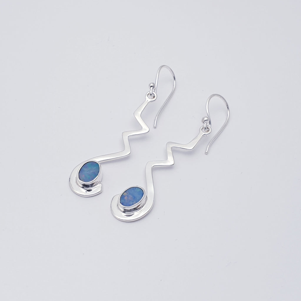 Measuring a gorgeous 5 cm in length, these earrings are long enough to create an impact but dainty enough for them not to be overpowering, bringing a touch of elegance to any outfit.   These earrings feature a flowing zig-zag design worked in Sterling Silver. At the bottom of each earring the silver gently curls round a beautiful Australian Opal Doublet finishing off the design perfectly.