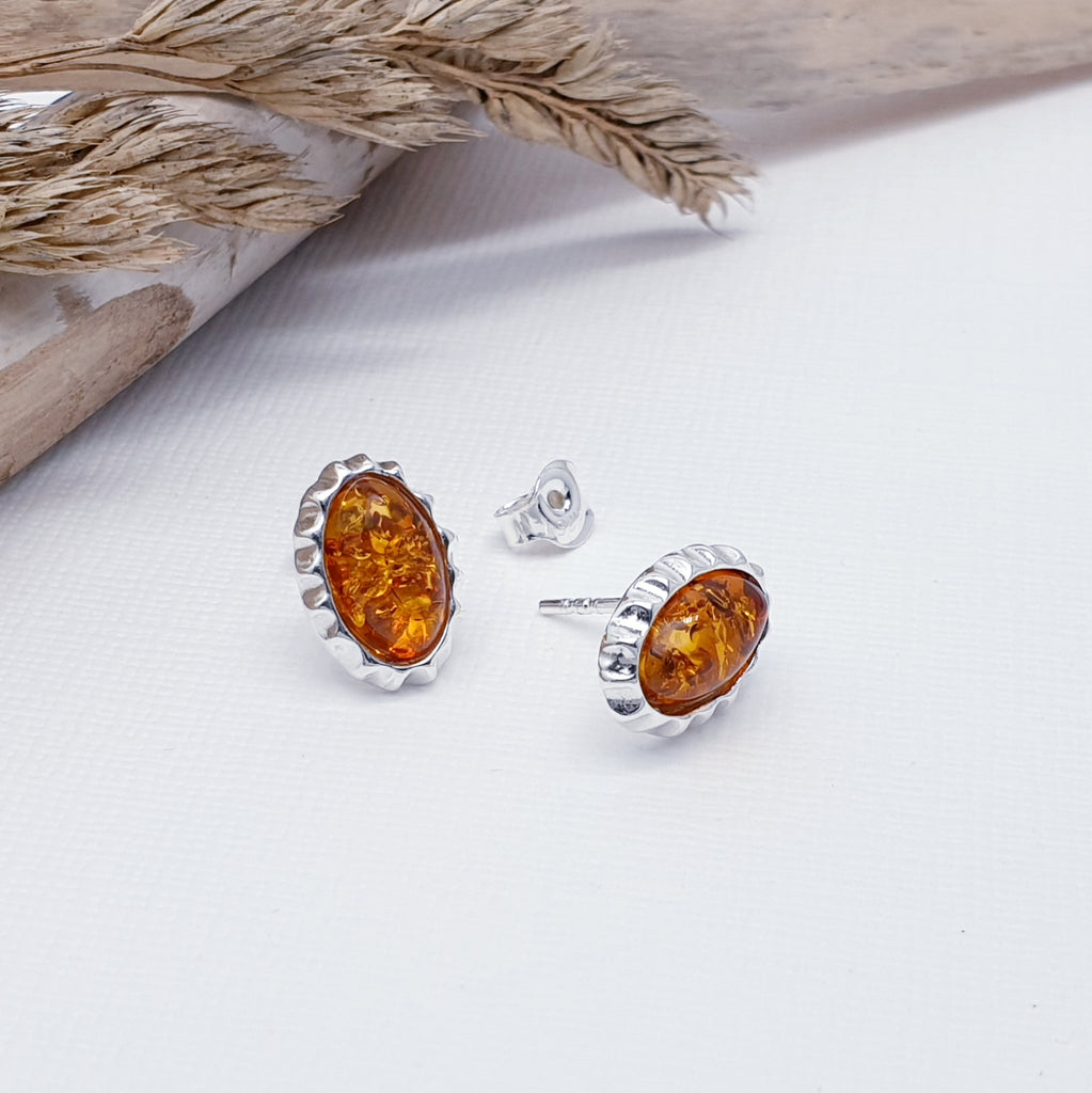 The cutest design, each earring features an oval Baltic Toffee Amber stone. The Amber stones are highlighted by a Sterling Silver crimped texture effect. These earrings are the finishing touch to any outfit, you just can't go wrong with this understated pair of studs. 