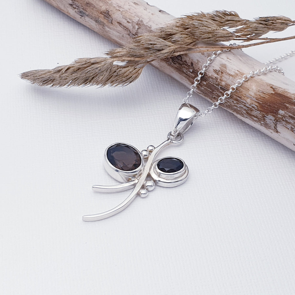 This pendant features two oval, table top cut, Smoky Quartz stones in simple settings. A bow design has been hand-worked in Sterling Silver by our silversmiths, with the stones being the loops of the bow. An unusual and fun design, this little pendant is bound to become a favourite.