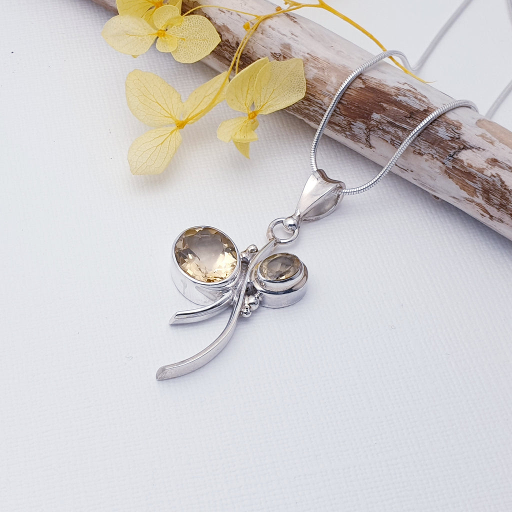 This pendant features two oval, table top cut, Citrine stones in simple settings. A bow design has been hand-worked in Sterling Silver, by our silversmiths with the stones being the loops of the bow. An unusual and fun design, this little pendant is bound to become a favourite.