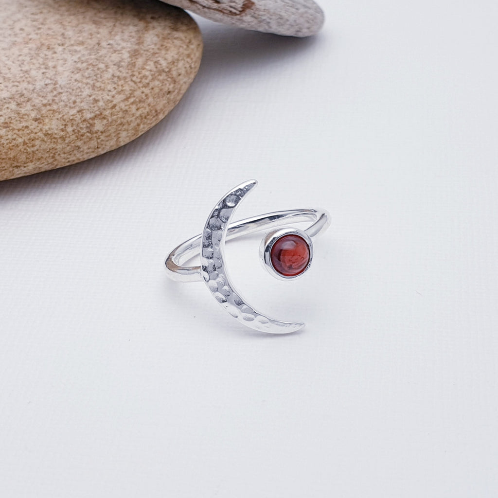 A gorgeous design, this ring features a beautiful cabochon, round Garnet stone in a simple setting. To complement a hammered Sterling Silver crescent moon, wraps comfortably around the finger. 