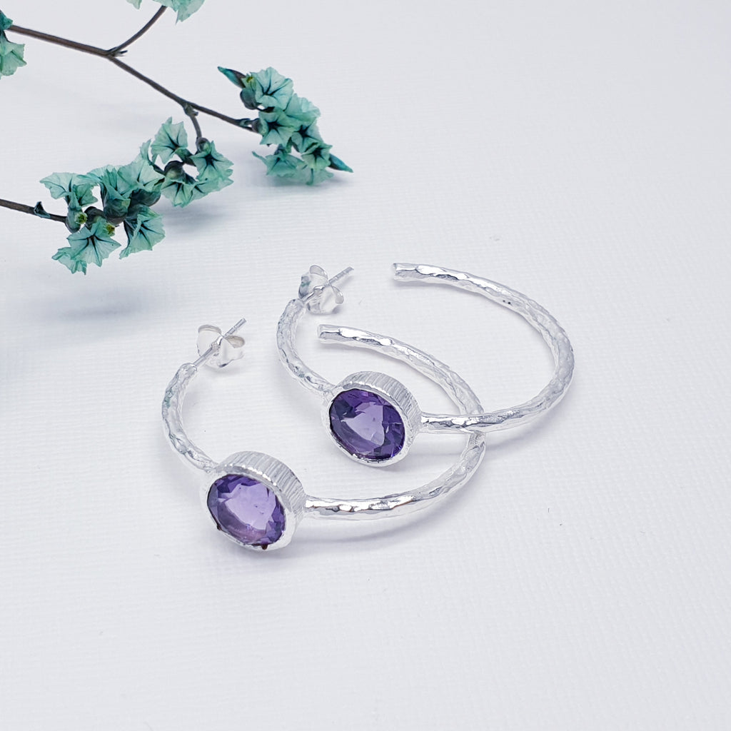 Each earring features a half hoop design with a beautiful, cabochon, Amethyst stone in a Sterling Silver setting. Each hoop has a Sterling Silver hammered effect creating that 'something a little different' we love at Silver Scene. The stud fixing makes these earrings extra secure so you don't need to worry about loosing them.
