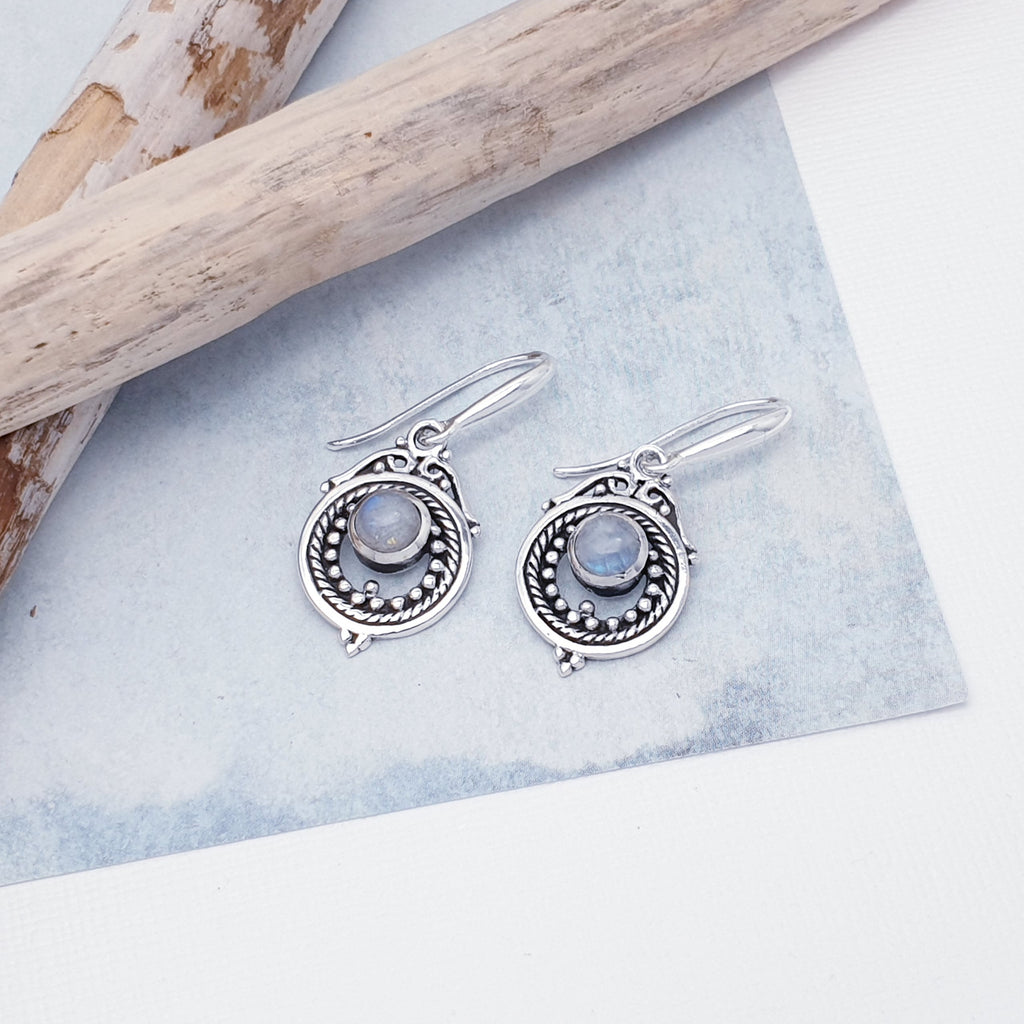 Each earring features a round, cabochon Moonstone stone in a simple setting. Intricate Sterling Silver detailing decorates around the stone, and is given depth and presence by the clever use of oxidisation. 