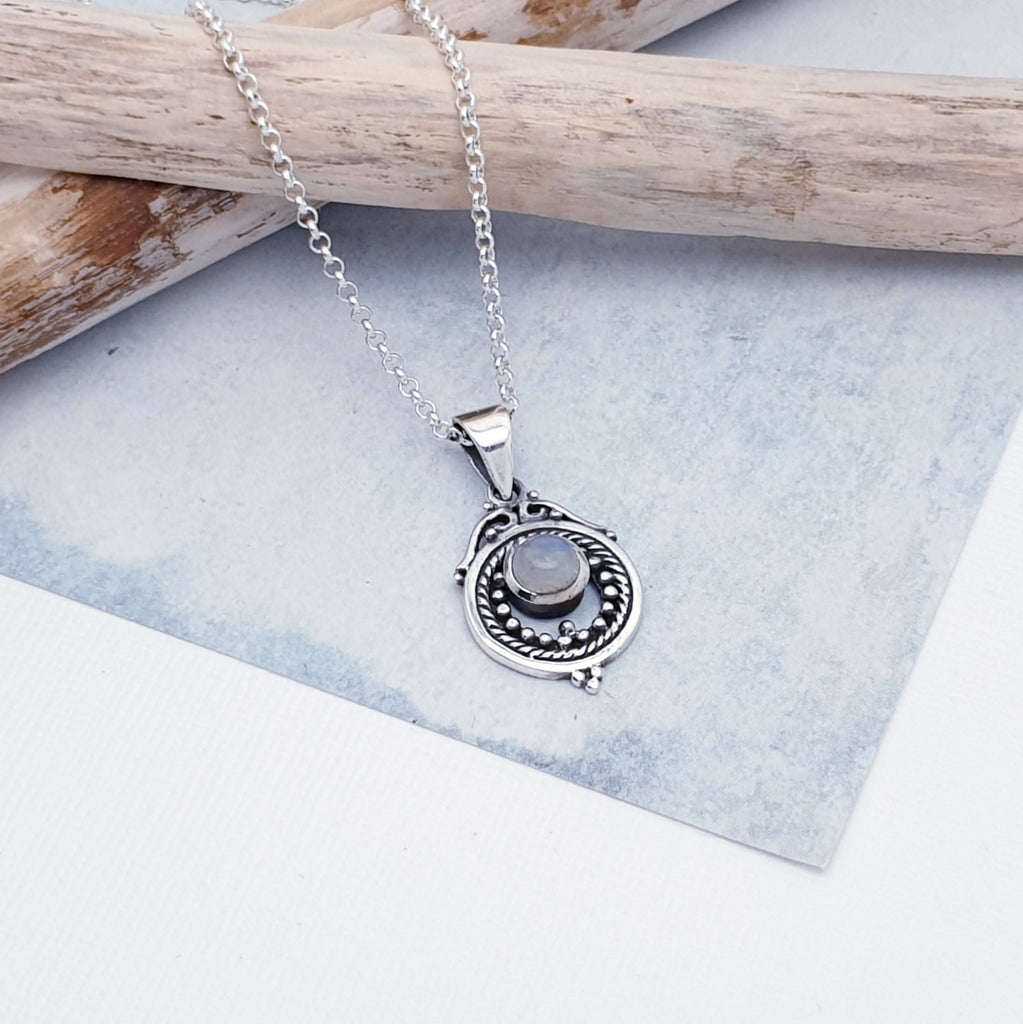 A gorgeous design, this pendant features a round, cabochon Moonstone in a simple setting. Intricate Sterling Silver detailing decorates around the stone, and is given depth and presence by the clever use of oxidisatio