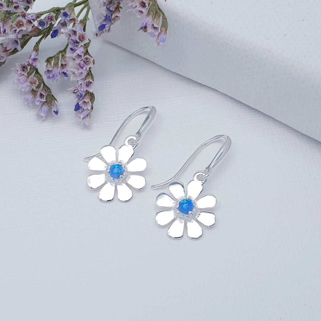 A dainty design, each earring features a round cabochon Reconstituted Opal. The Opals are highlighted by decorative Silver petals creating a detailed daisy. These earrings will add sparkle and shine to any outfit, you just can't go wrong with this understated pair of studs. 