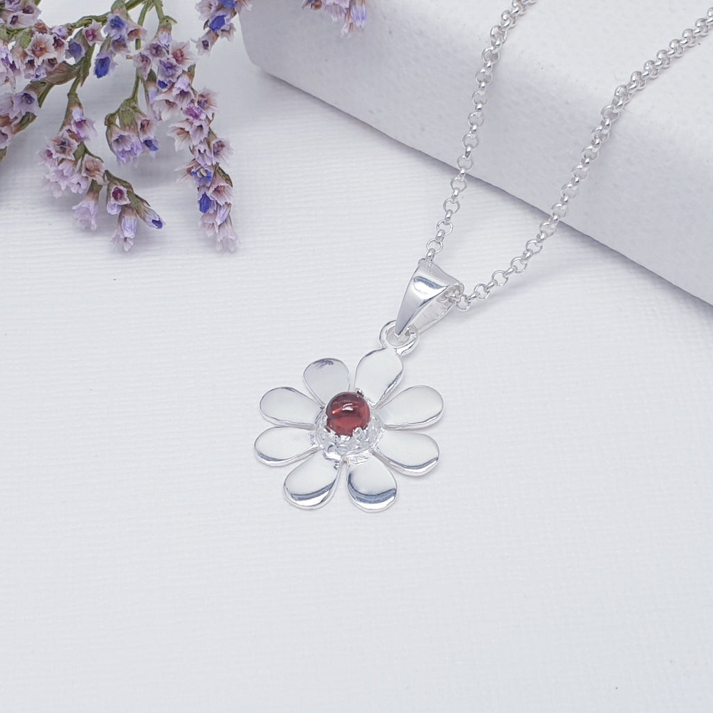 This pendant features a round cabochon Garnet. The Garnet stone is highlighted by decorative Silver petals creating a detailed daisy.  A beautiful little pendant, this is bound to become an everyday favourite.