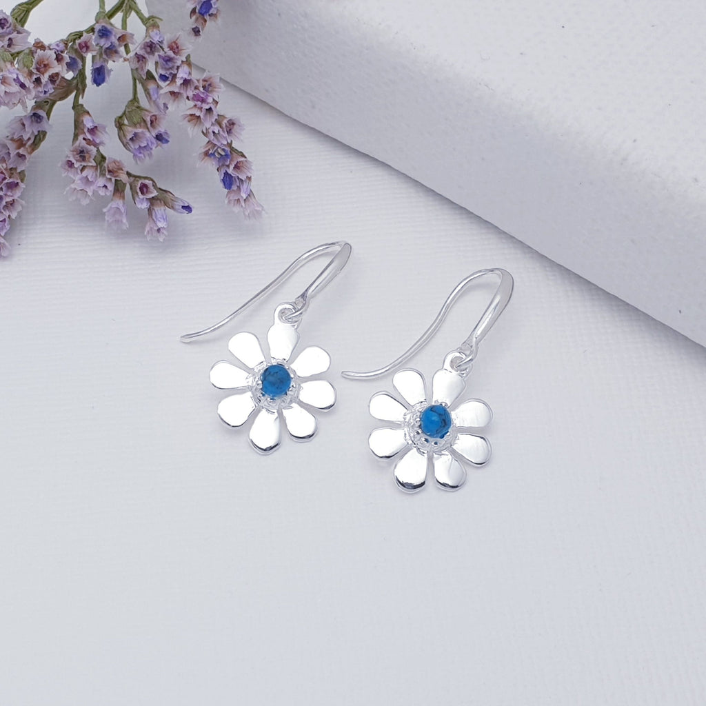 A dainty design, each earring features a round Turquoise stone. The stones are highlighted by decorative Silver petals creating a detailed daisy. These earrings will add sparkle and shine to any outfit, you just can't go wrong with this understated pair of studs. 