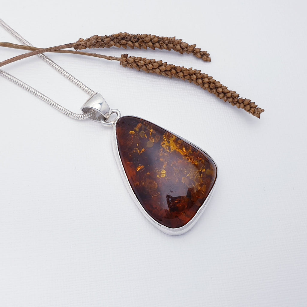 This pendant features a beautiful free form Toffee Baltic Amber stone in a Sterling Silver setting.  This pendant is perfect worn on a short chain as a statement piece, or on long chain layered with other necklaces creating your own unique look.