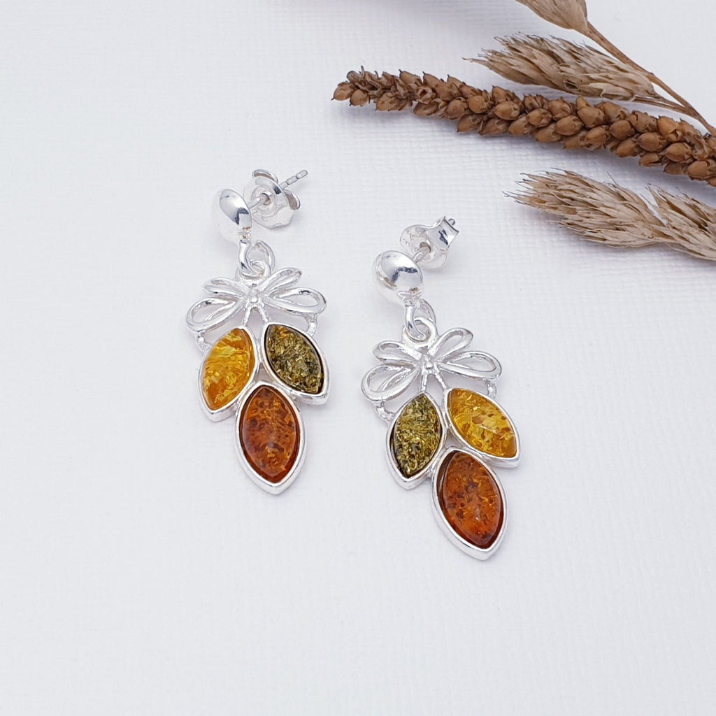 Each earring features three marquise shaped, yellow, green and Toffee Amber Stones. Above, a decorative Sterling Silver bow design has been handcrafted, adding a feminine touch. This pair of earrings will soon become firm favourites. The Sterling Silver stud fixing makes these earrings extra secure so you won't need to worry about loosing them. 