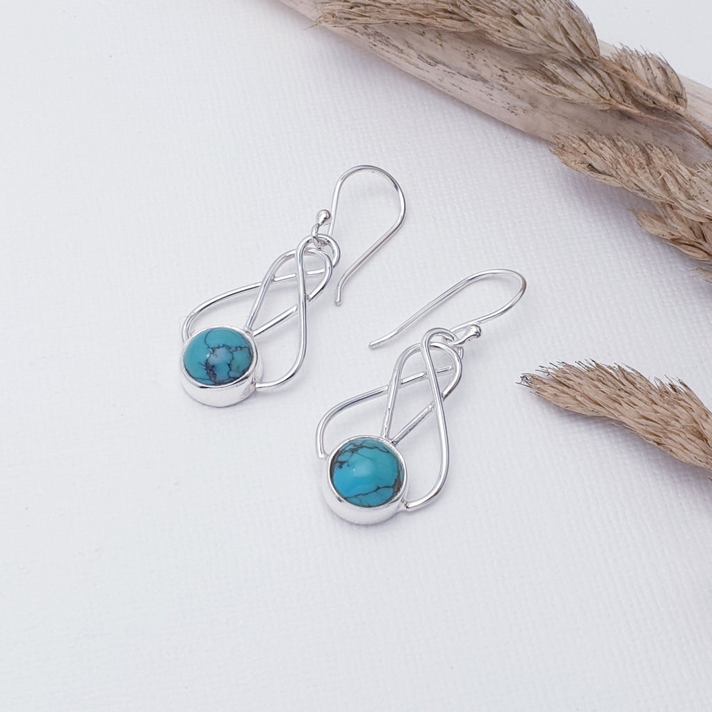 Our Turquoise Sterling Silver Danu Earrings are perfect for everyday wear or special occasions.  Each earring features a circular cabachon, Turquoise stone in a simple setting. Above the stone, our silversmiths have created a gorgeous criss-cross Celtic inspired design. These earrings are light on the ear, easy to wear and will soon become everyday favourites.