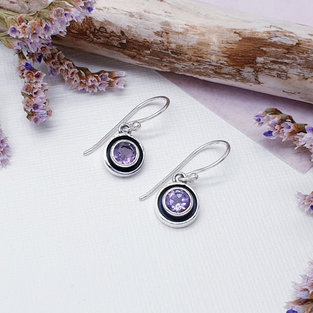 Our Amethyst Sterling Silver Dainty Circle Earrings are perfect for everyday wear or special occasions.  With an understated design, these earrings feature beautiful circular, tabletop cut, amethyst stones in simple Sterling silver settings. The technique of oxidization has been used to create a shadow around the stone, emphasizing its beauty. Nice and simple, these little earrings are the perfect complement to any outfit or occasion.