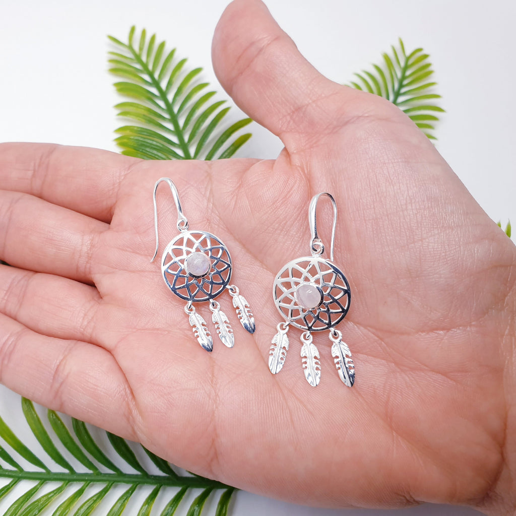 Our Moonstone Sterling Silver Dream Catcher Earrings are perfect for everyday wear or special occasions.  These stunning earrings features small, cabochon Moonstone's in the center of a beautifully detailed dream catcher, with three dangly feathers. These dainty earrings are ideal for women and girls of all ages.