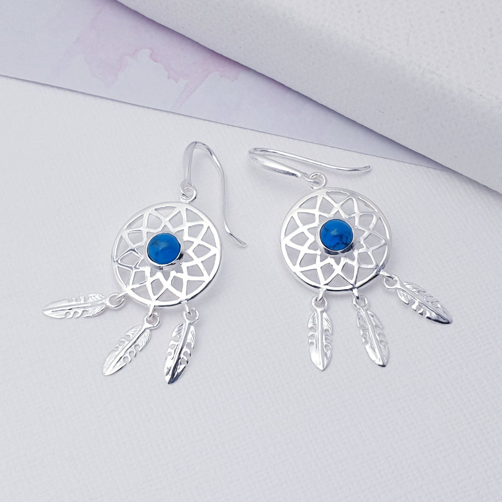 Our Turquoise Sterling Silver Dream Catcher Earrings are perfect for everyday wear or special occasions.  These stunning earrings features small, cabochon Turquoise's in the center of a beautifully detailed dream catcher, with three dangly feathers