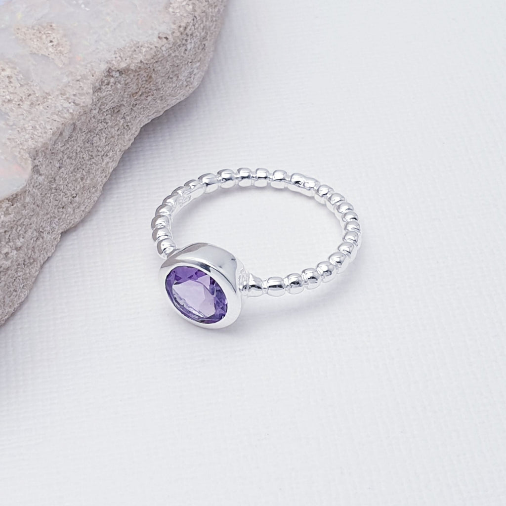 Our Amethyst Feather Ring is perfect for everyday wear or special occasions.  A beautiful design, this ring features a stunning, tabletop cut Amethyst stone in a simple lowered setting. The band is shaped in a bubble-like ball design, to add extra detailing.