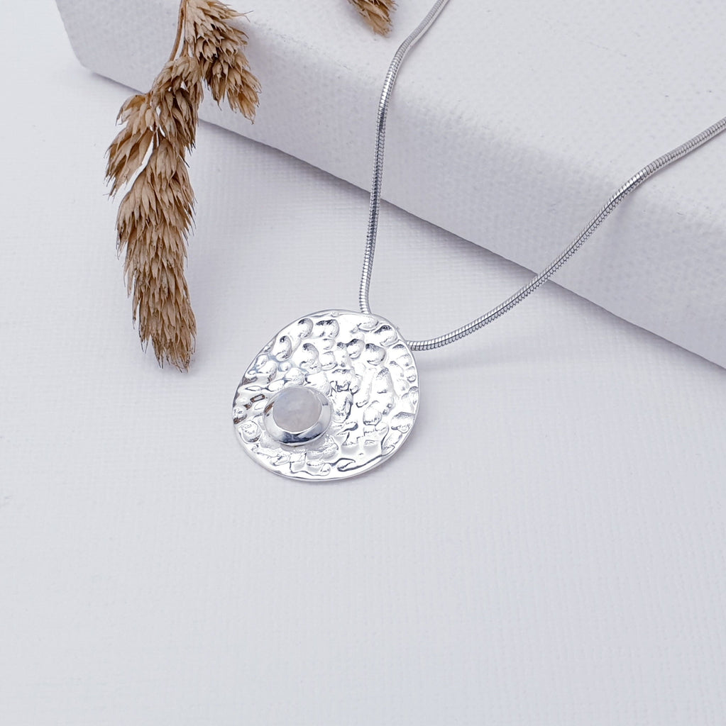 Our Moonstone Sterling Silver Hammered Disk Pendant (chain not included) is so cute and would be perfect for everyday wear.  This stunning pendant features a small, cabochon Moonstone sitting off-center on a beautiful, hammered Sterling Silver disk. This textured effect creates a stunning, reflective surface which catches the light as you move. 