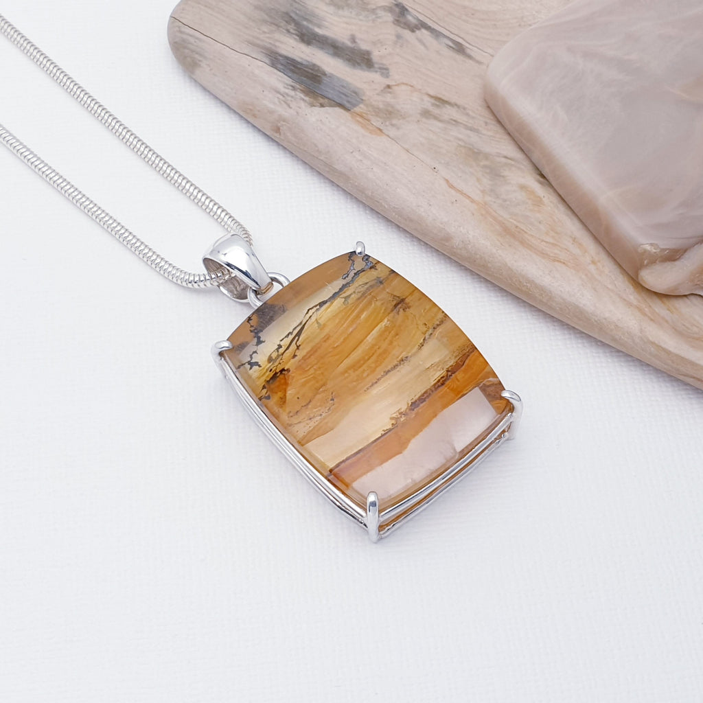 Our beautiful One-off Dendritic Quartz Rectangle Claw Set Pendant (chain not included) is perfect for everyday wear or special occasions.  This pendant features a stunning cabochon, rectangular, Dendritic Quartz stone. The stone is set in a claw setting, with four minimalist Sterling Silver claws to keep the stone nice and secure. 